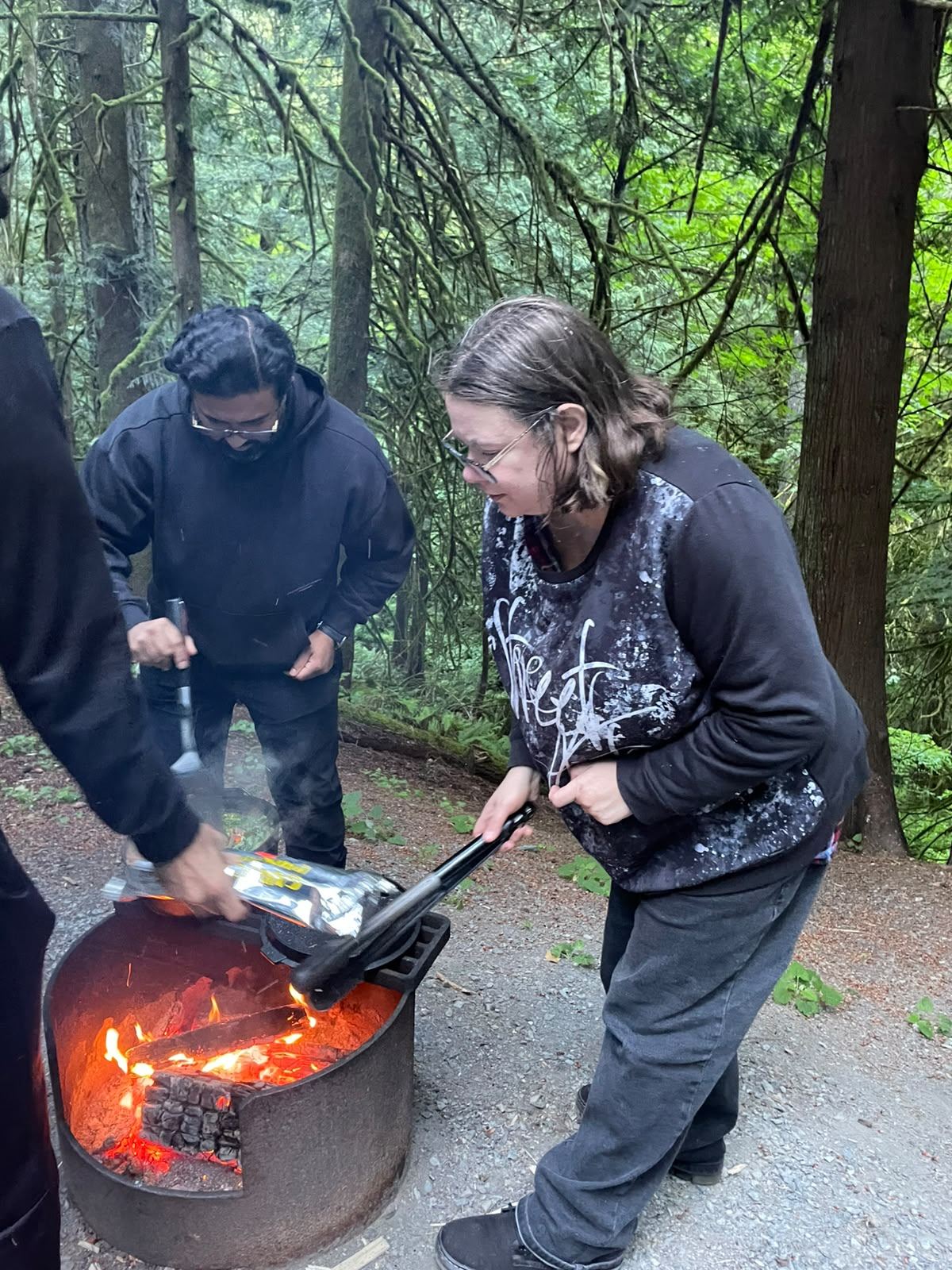 Members cooking dinner over the campfire