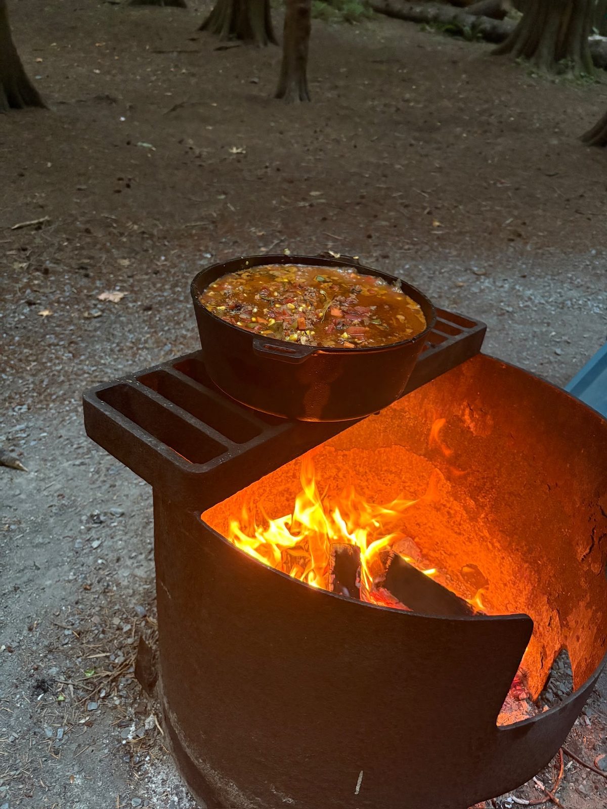 Close-up of the chili simmering in a cast iron pot on the fire grate